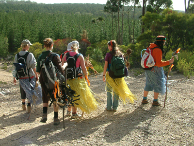 Venturers wearing jungle themed costumes hiking along gravel track